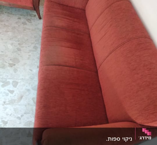 ספה אדומה עם כתמים על הידיות